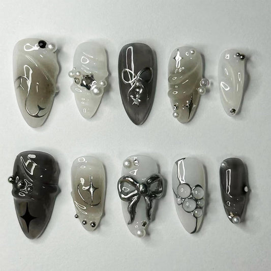 LBPEPAMZ Black Press on Nails Medium Almond Fake Nails with 3D Alloy Bow Pearl Designs Black Gradient Full Cover False Nail Water Drops Silver Star Glossy Acrylic Nails Stick on Nail for Women 24Pcs
